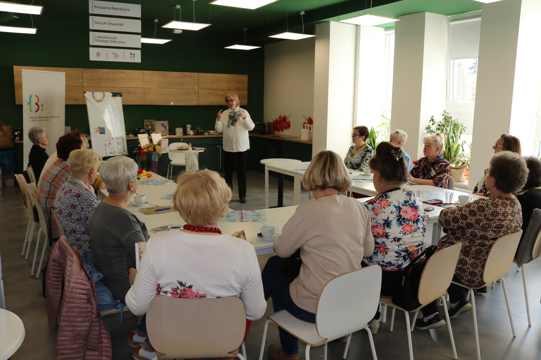 Seniorzy 65+ podczas spotkania Dojrzałych Wspaniałych w bibliotece